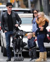 Neil Patrick Harris hails a cab in New York City while an unidentified woman holds his twin chil.jpg