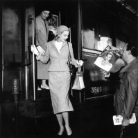 Grace Kelly arrives for the Cannes film festival and is presented with a copy of Ciné Revue fr...jpg